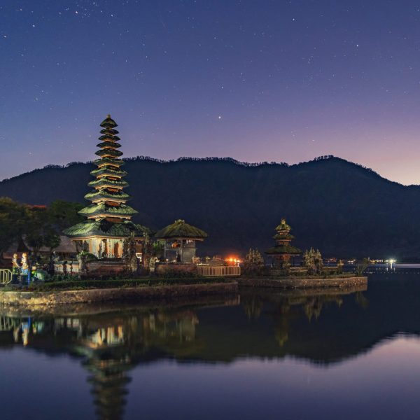 Pura Ulun Danu Bratan Temple, a Hindu temple at night with mountain, lake, and stars, in Bali island, Indonesia. Natural landscape background.